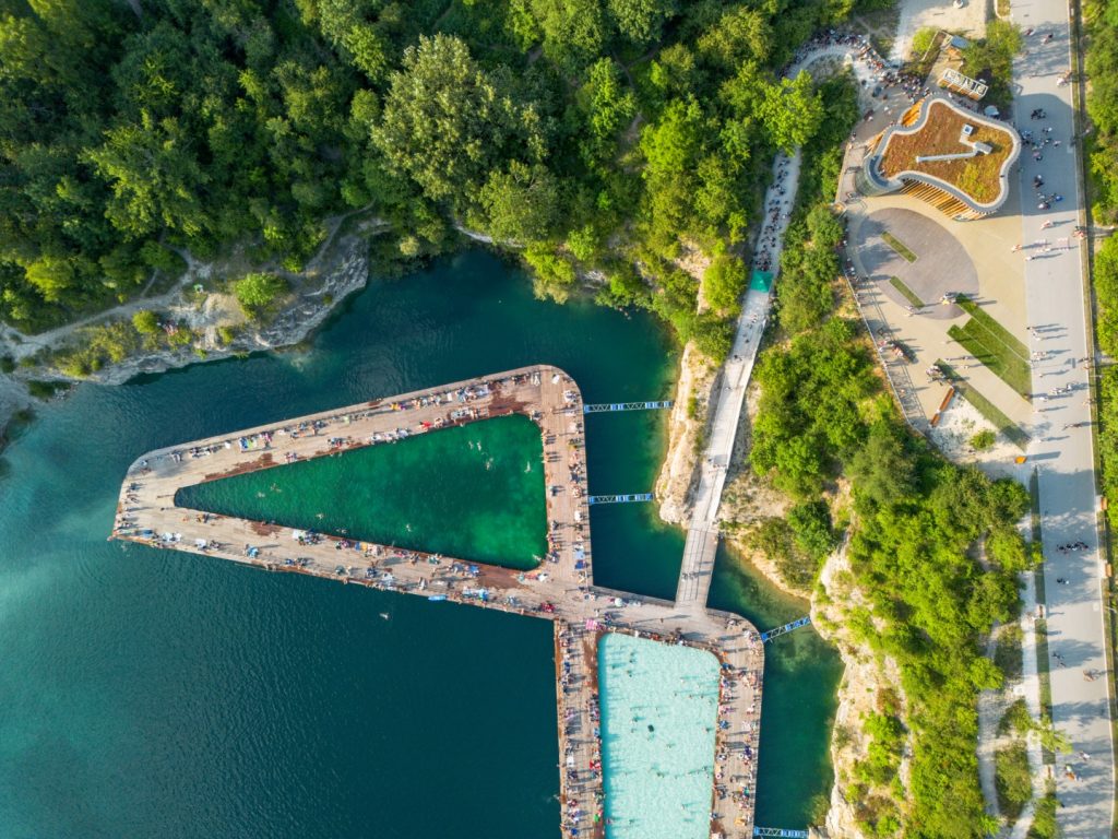 Aerial view of Zakrzówek Quarry in Krakow, showcasing turquoise water and surrounding greenery, perfect for nature lovers