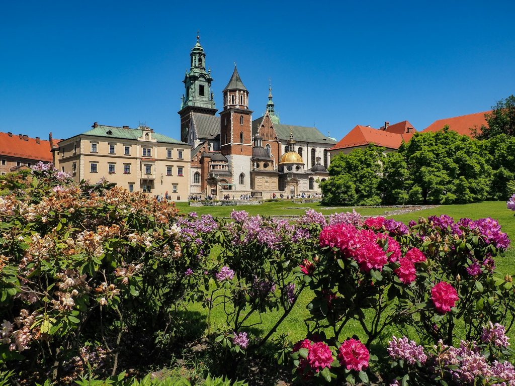 Wawel Castle with blooming flowers in the foreground on a sunny day in Krakow, perfect for a city stroll