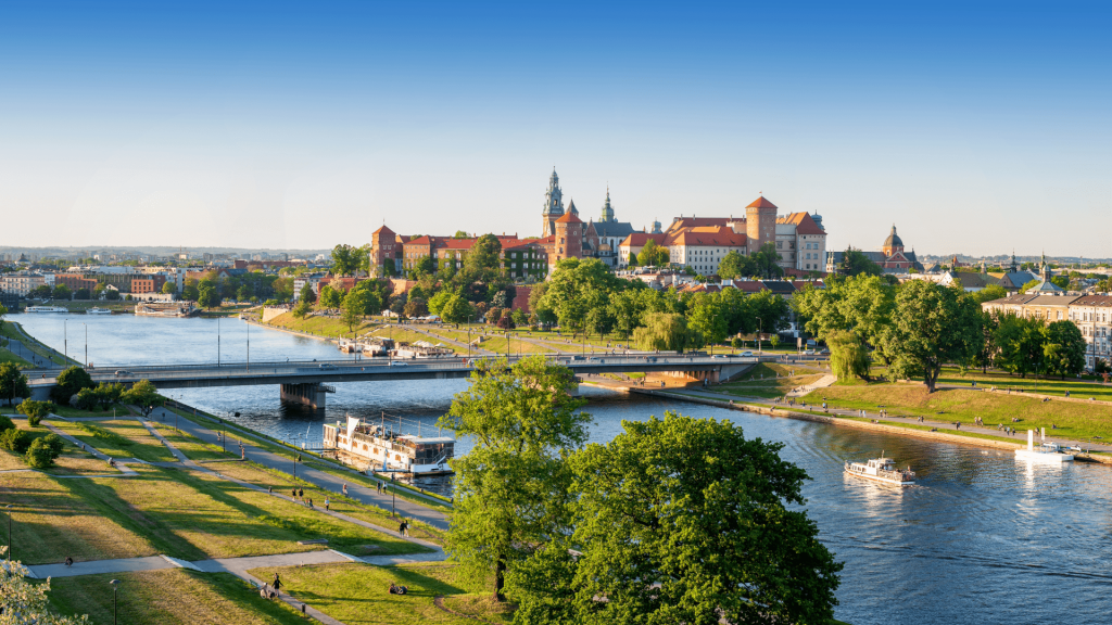 Vistula River flowing through central Krakow on a sunny summer day, with Wawel Castle visible in the background