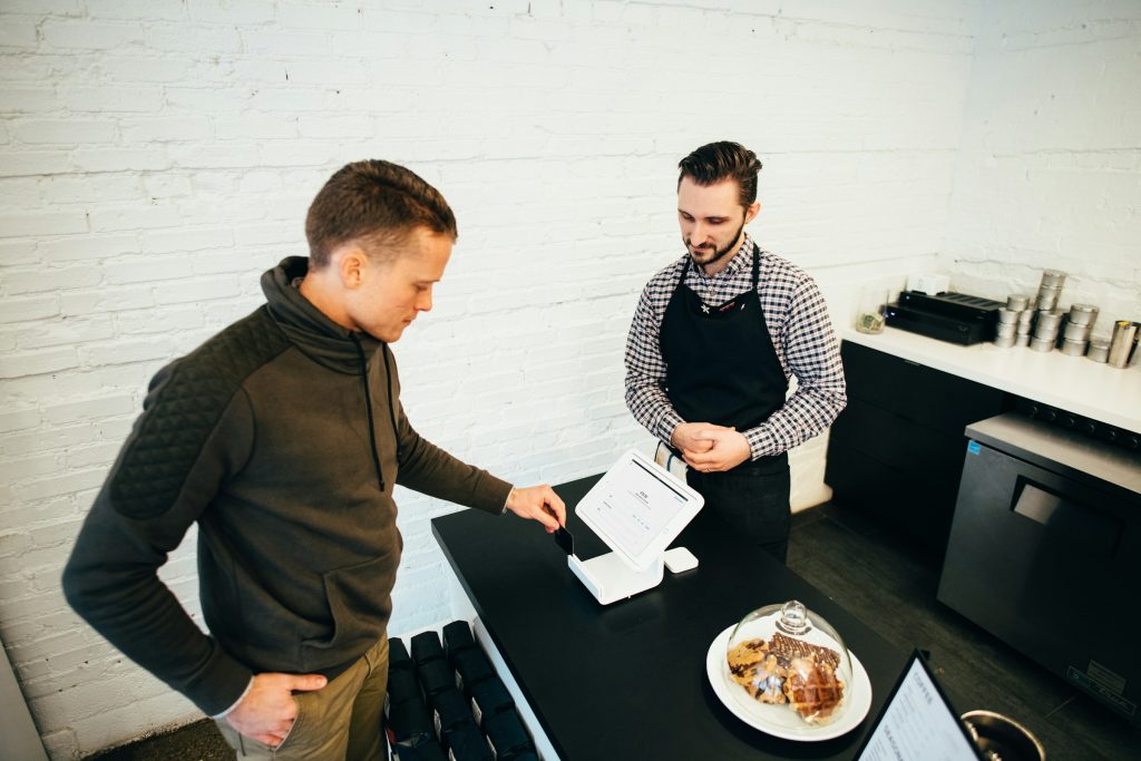 Customer paying by card at café counter