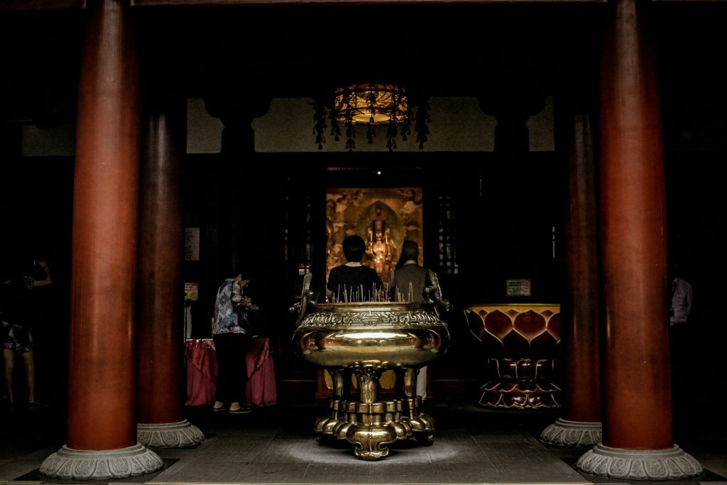 Worshippers lighting incense inside a traditional Chinese temple in Singapore.