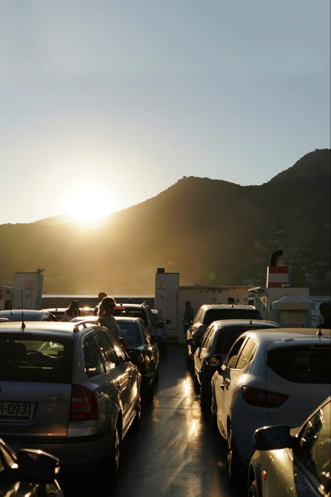 Cars parked on ferry deck at sunset