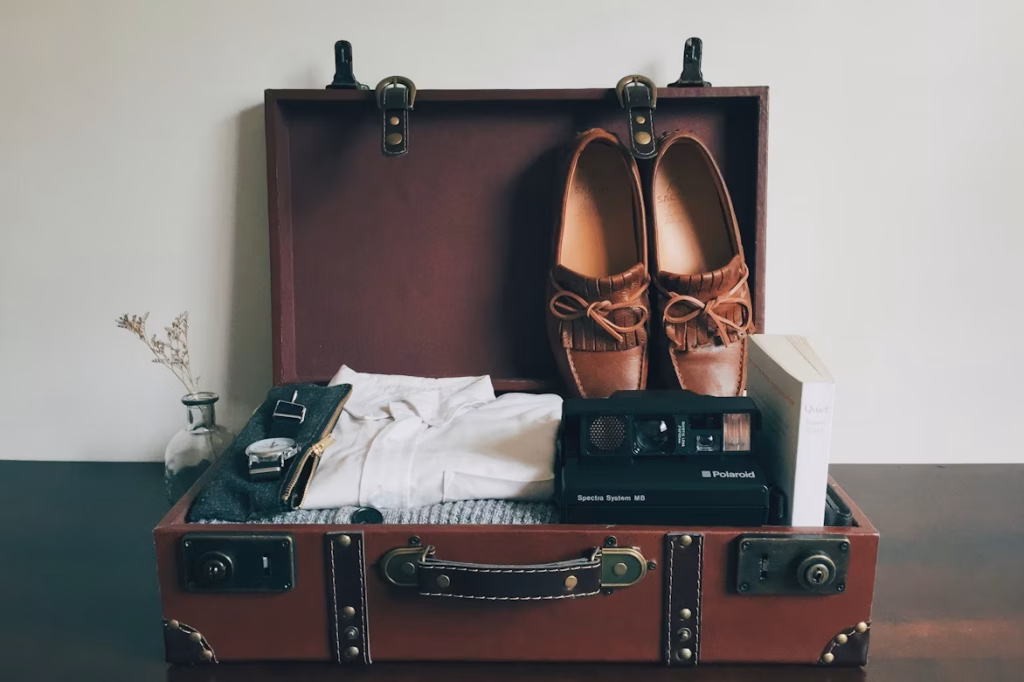 Open suitcase packed with clothes and shoes for a short trip